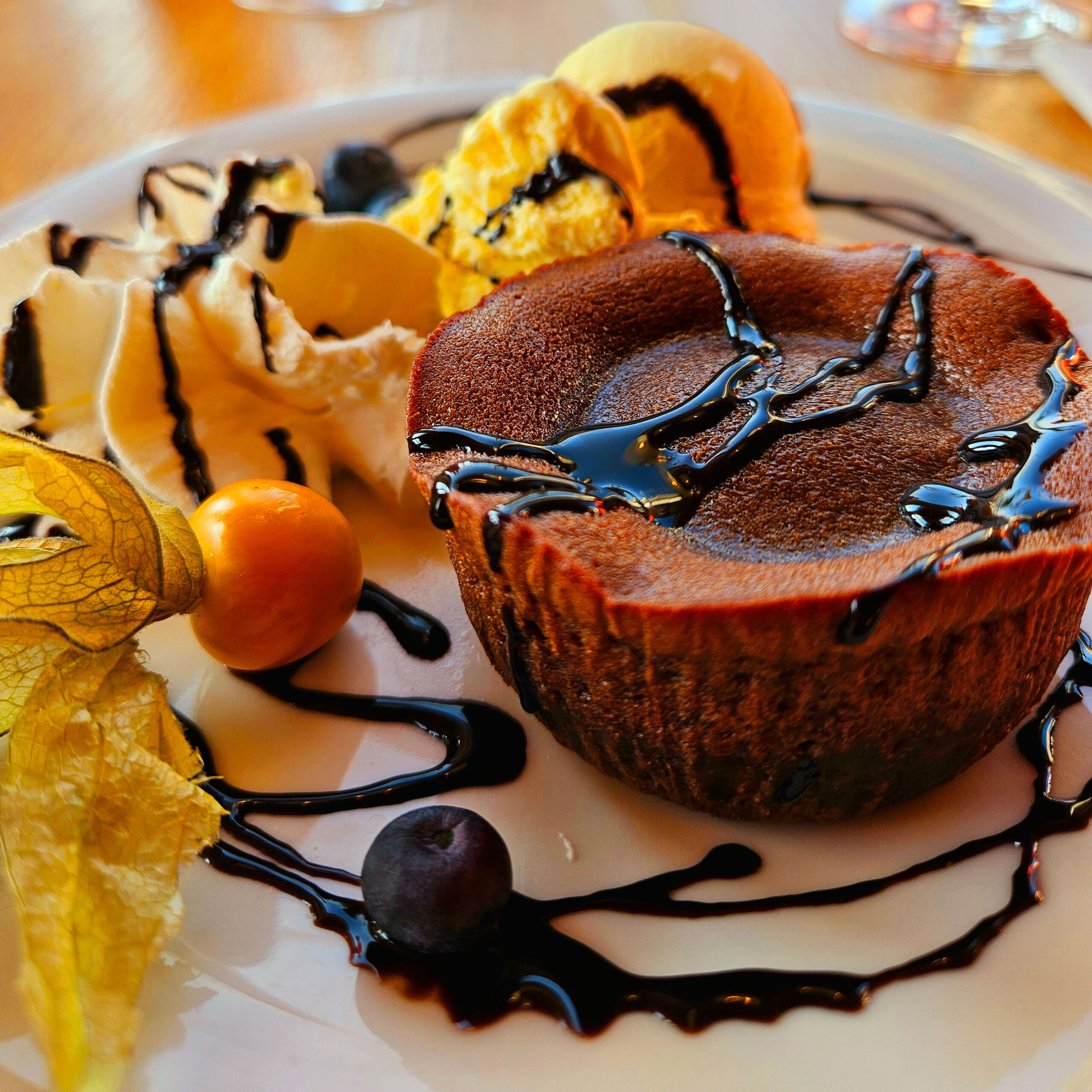 Ein warmes Lavacake mit Schokoladensauce, serviert mit Sahne und Früchten, lädt im Strandcafé Sturmeck zum Genießen ein.